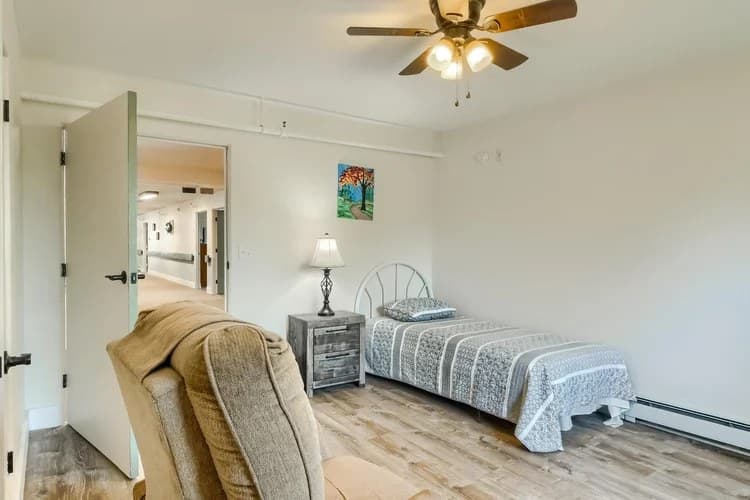 Private resident bedroom with bed, recliner, and hallway view at Aspen Leaf Circle Lane