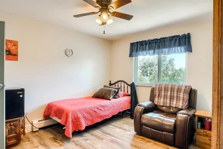 Comfortable resident room with bed, recliner, and window at Aspen Leaf Circle Lane