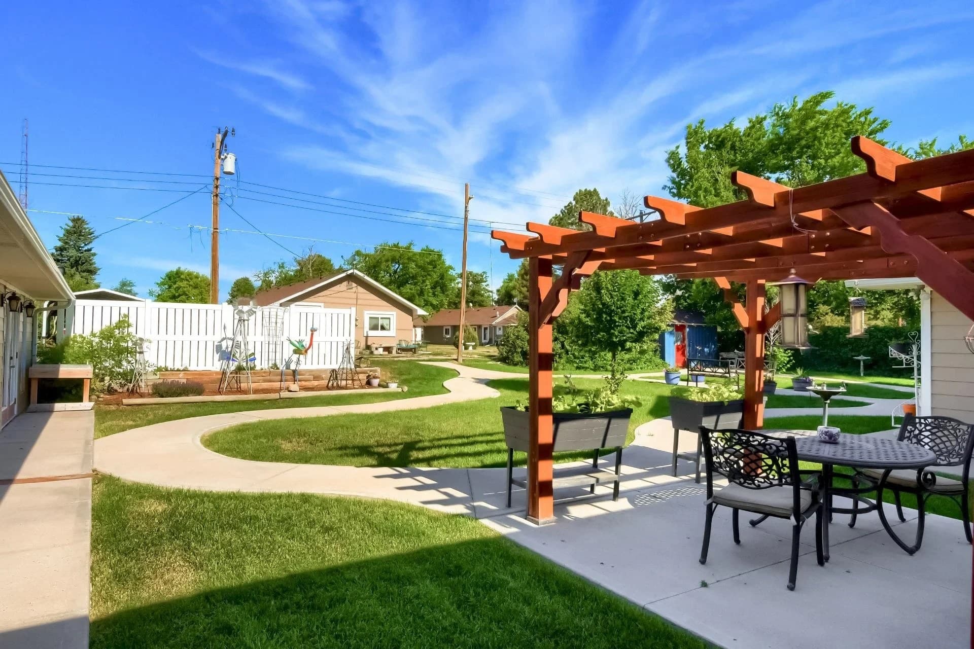 Covered pergola patio with seating and raised garden beds at Aspen Leaf Flagler