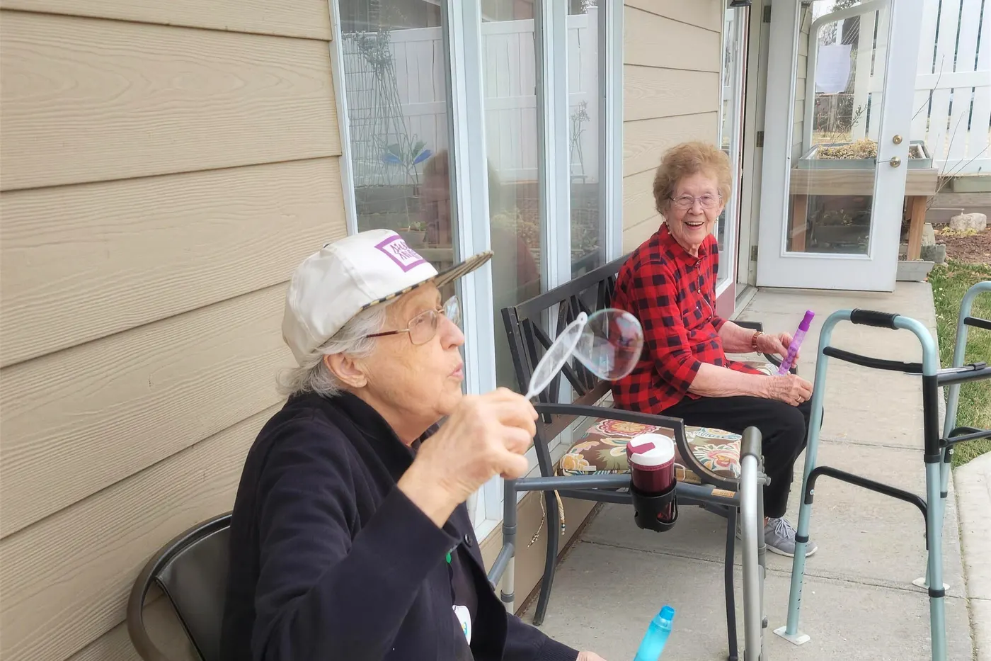 Two residents sitting together in the sunroom at an Aspen Leaf home in Eastern Colorado