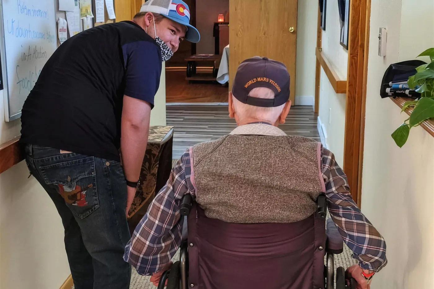 A caregiver stopping to talk with a resident in the hallway of an Aspen Leaf home